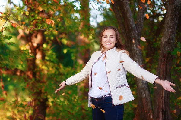 Jovem bela adolescente menina joga folhas de outono coloridas no parque — Fotografia de Stock