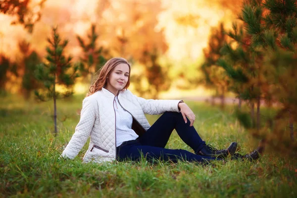 Joven mujer hermosa. Belleza adolescente chica sentado en otoño parque — Foto de Stock