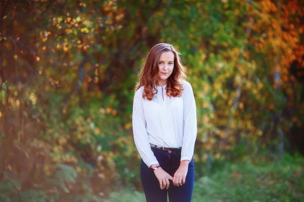 Jovencita. Sonriente chica bonita posando en colorido parque de otoño — Foto de Stock