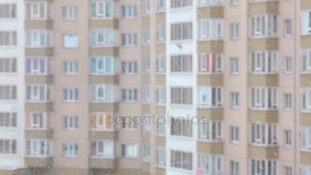 Copos de nieve cayendo, vista de ventana de invierno. Edificio de apartamentos. Fondo borroso — Vídeos de Stock