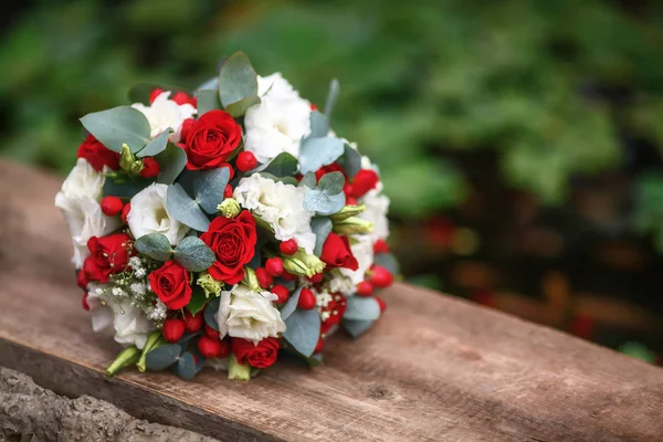 Hochzeitsstrauß aus Rosen auf hölzernem Hintergrund, rot und weiß — Stockfoto