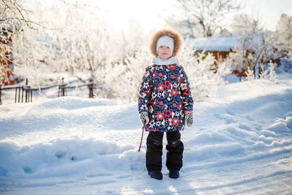 Zimowa scena, małą dziewczynkę stojącą na zaśnieżonej drodze — Zdjęcie stockowe