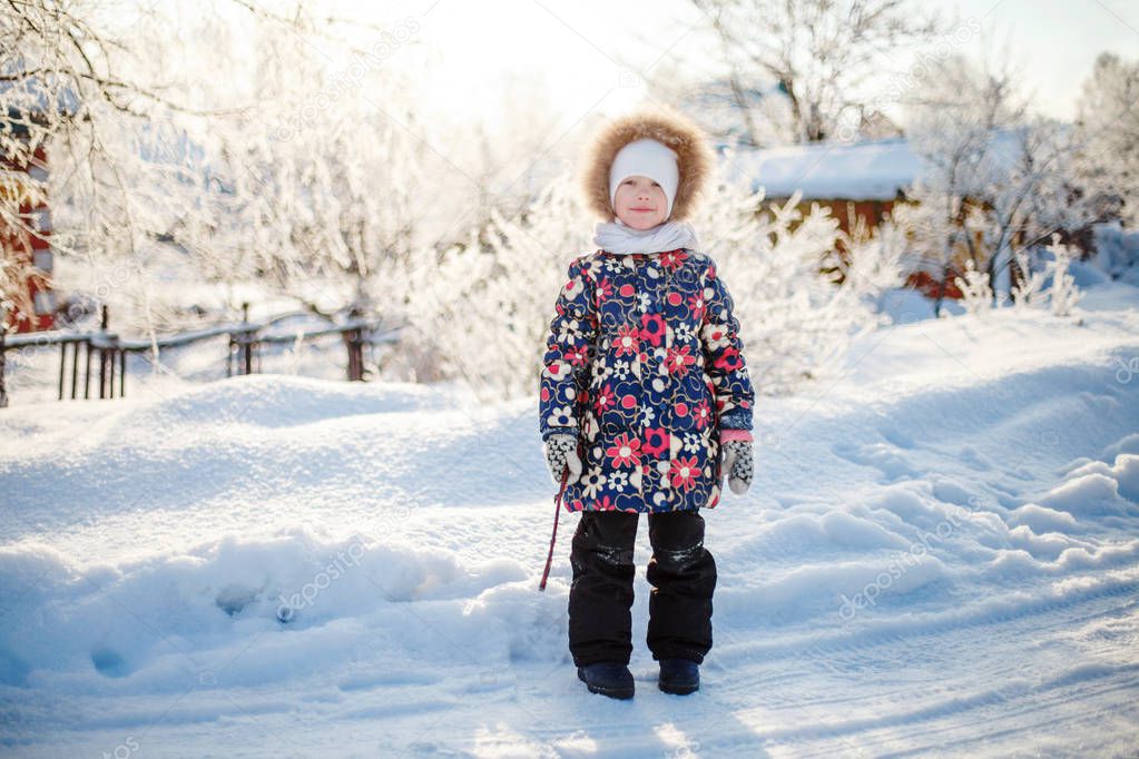Winter rural scene, little girl standing on snowy road