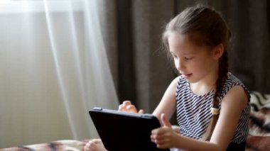 Bir tablet bilgisayar oynamak sevimli küçük çocuk kız
