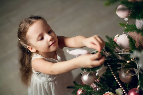 Cute little girl in dress decorating christmas tree — Stock Photo, Image