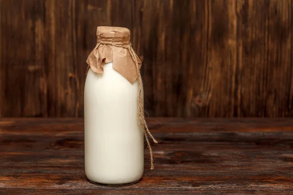 Fles melk op rustieke houten tafel — Stockfoto