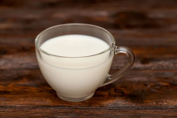 Primer plano de taza con leche sobre mesa de madera rústica — Foto de Stock
