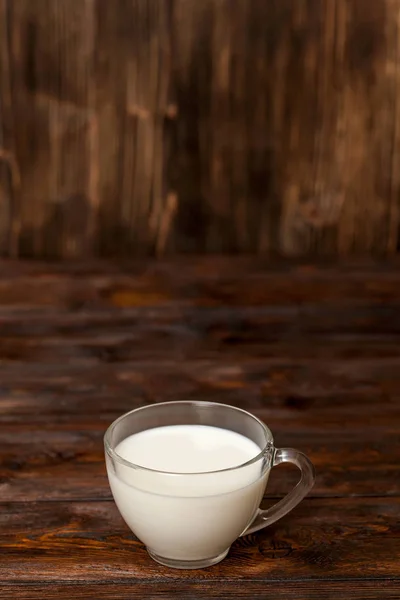 Copa de leche sobre mesa rústica de madera —  Fotos de Stock