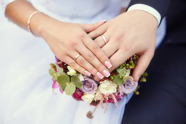 Hände von Braut und Bräutigam am Brautstrauß. Ehekonzept — Stockfoto