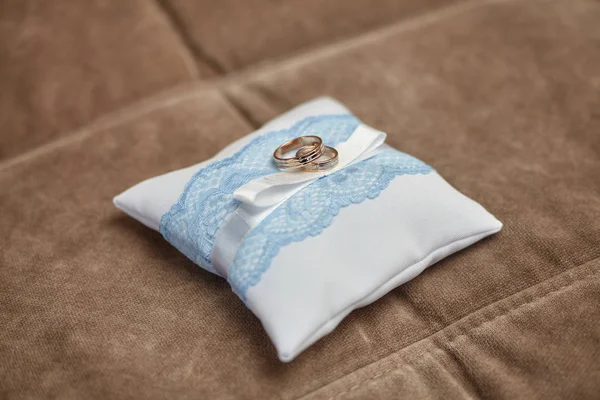Altın alyans dekore edilmiş küçük beyaz yastık üzerinde. Evlilik kavramı