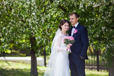 Genç damat ve gelin düğün buket çiçek bahçesinde ile