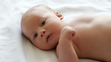 Yatakta yatarken ve bakarak küçük yeni doğan bebek çocuk