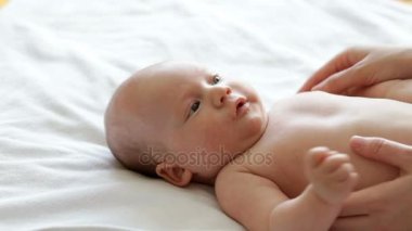 Anne onun yeni doğan bebek çocuk içeteklik ve ona masaj yapma