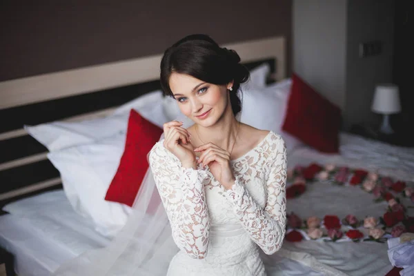 Giovane donna, sposa in hotel seduta sul letto — Foto Stock