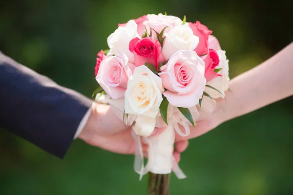 Красивий рожевий весільний букет в руках нареченої і нареченого — стокове фото