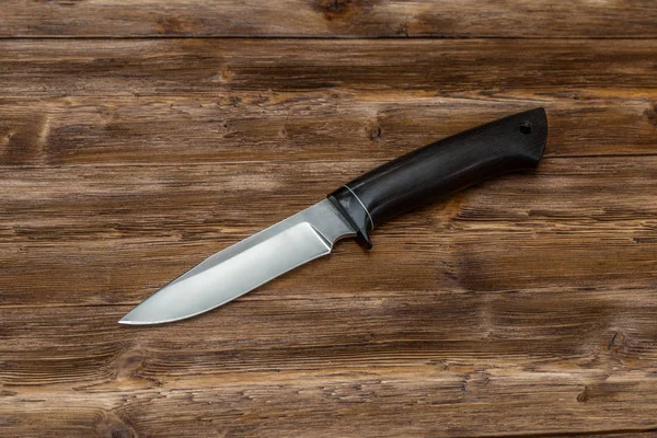 Couteau en acier de chasse fait à la main sur un fond en bois, gros plan — Photo