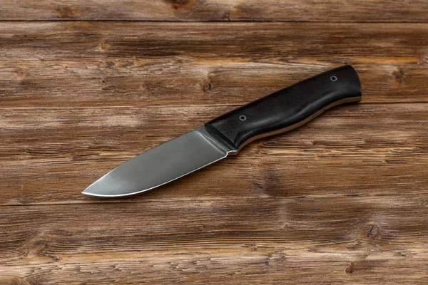 Cuchillo de acero de caza hecho a mano sobre fondo de madera, primer plano —  Fotos de Stock
