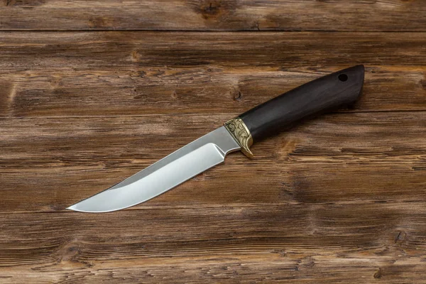 Cuchillo de acero de caza hecho a mano sobre fondo de madera, primer plano — Foto de Stock