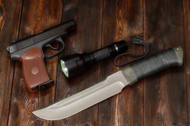 Çelik bıçak, el feneri ve silah ahşap zemin, yakın çekim