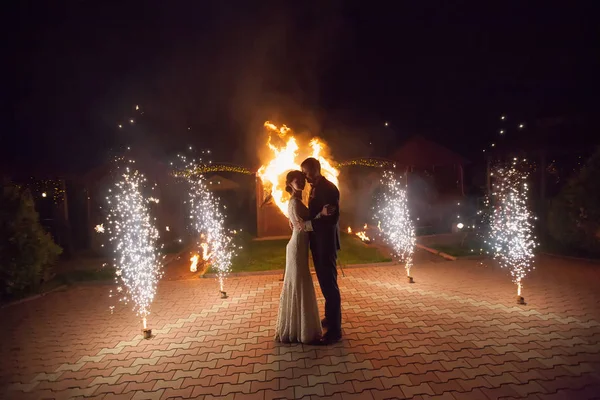 Jonge bruidegom en bruid met twee brandende harten vuurshow — Stockfoto