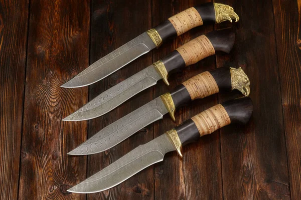 Caza cuchillos de acero damasco hechos a mano sobre un fondo de madera, primer plano — Foto de Stock