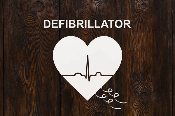 Forma del corazón con ecocardiograma y texto DEFIBRILLATOR. Concepto de cardiología — Foto de Stock