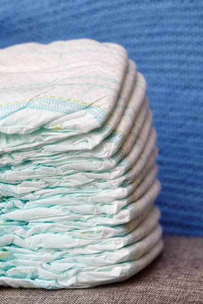 Pilha de fraldas ou fraldas em fundo de malha azul — Fotografia de Stock