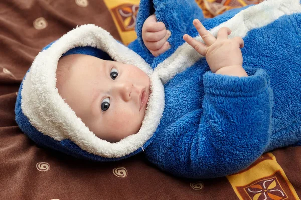 침대에 누워 파란 가운에 귀여운 아기 — 스톡 사진