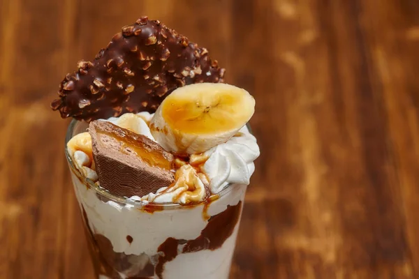 Морозиво шоколадний коктейль у склянці з сиропом та бананом — стокове фото