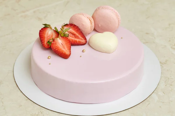 Różowy musem ciasto lustro glazury, ozdobione macarons i truskawka — Zdjęcie stockowe