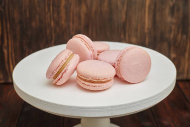Beyaz üzerine pembe macaroons ahşap arka plan üzerinde ev yapımı yiyecek standı