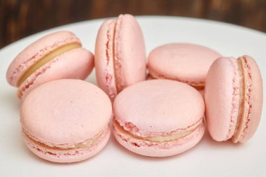Beyaz üzerine pembe macaroons ahşap arka plan üzerinde ev yapımı yiyecek standı
