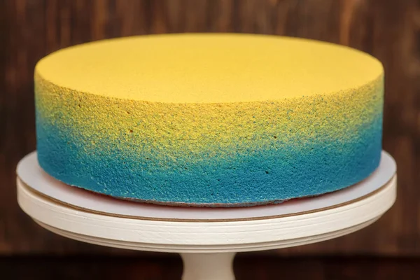 蓝色和黄色蛋糕上站在木制的背景 — 图库照片