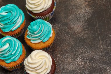 Turkuaz ve beyaz kahverengi zemin üzerinde buzlanma buttercream ile cupcakes