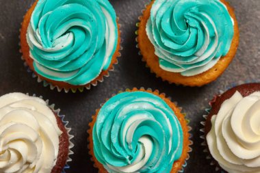 Turkuaz ve beyaz kahverengi zemin üzerinde buzlanma buttercream ile cupcakes