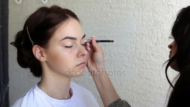 Visagistin schminkt junges Model im Salon — Stockvideo