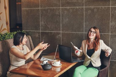 İki genç beyaz iş kadınları ile laptop, defter. Kadınlar Cafe