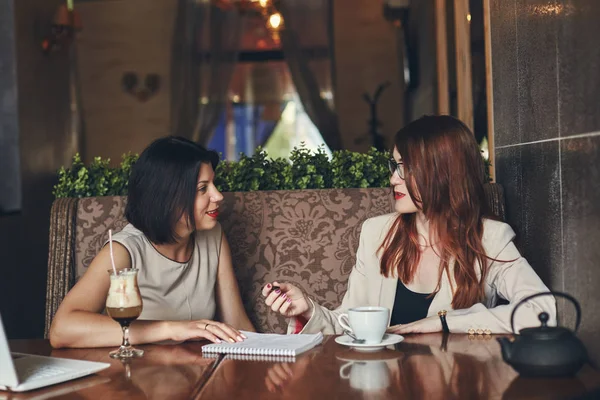 Twee jonge Kaukasische zakenvrouwen met laptop glimlachen. Vrouwen in café — Stockfoto