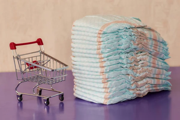 Pannolini o pannolini e mini carrello della spesa, concetto — Foto Stock