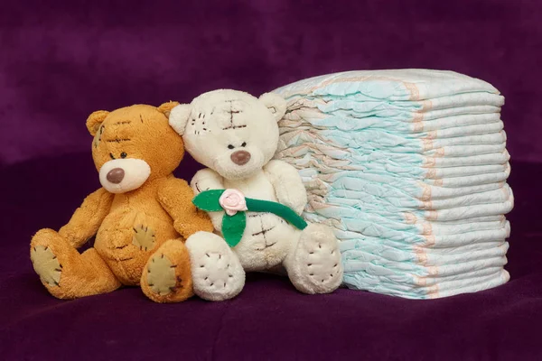 Stack of diapers or nappies with teddy bears, purple background — Stock Photo, Image