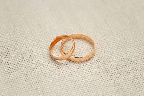 Two golden wedding rings on beige background, close up — Stock Photo, Image