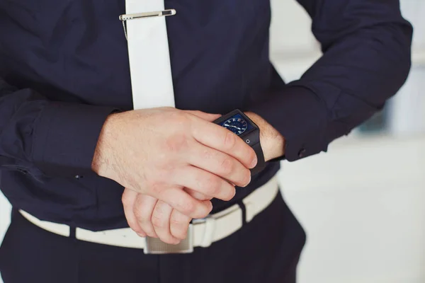 El novio en traje oscuro pone en un reloj, primer plano — Foto de Stock