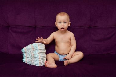 Küçük çocuk bezi veya çocuk bezi mor zemin üzerine yığını ile