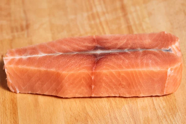 Filé de peixe cru de salmão no corte de tábua de madeira — Fotografia de Stock