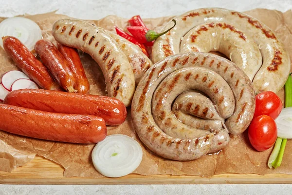 Набор жареных свиных колбас с овощами — стоковое фото