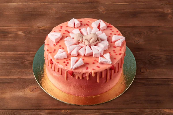 Рожевий дитячий торт для душу на дерев'яному фоні — стокове фото