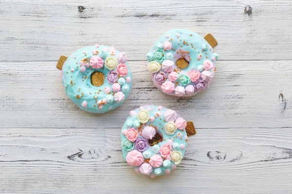 Donuts coloridos no fundo de madeira branco — Fotografia de Stock