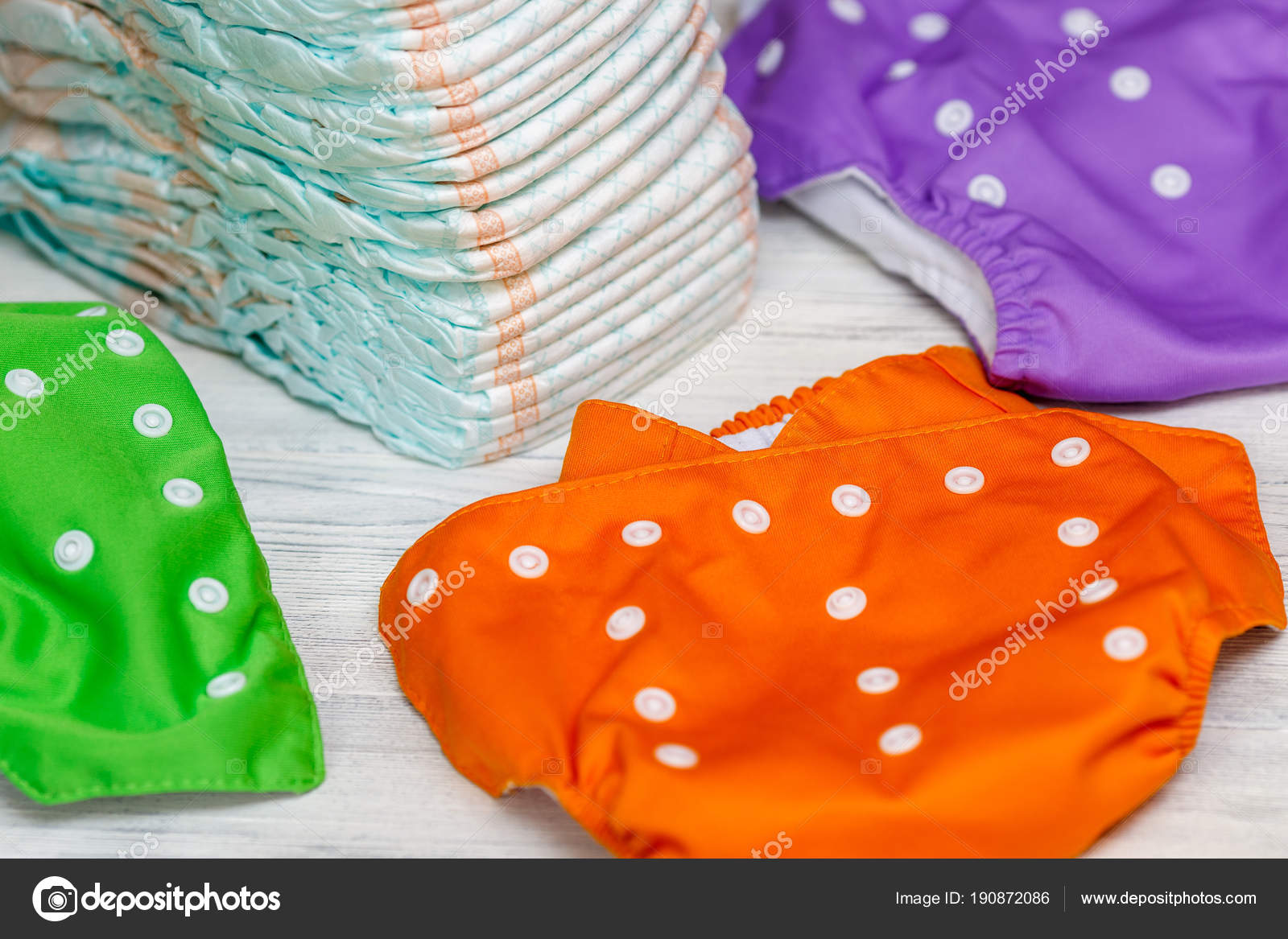 Stack of disposable diapers or nappies and colorful reusable Stock Photo by ©hdtexx.yandex.ru