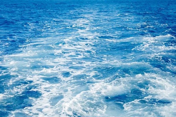 Blå havsyta bakgrund med stänk vågor — Stockfoto