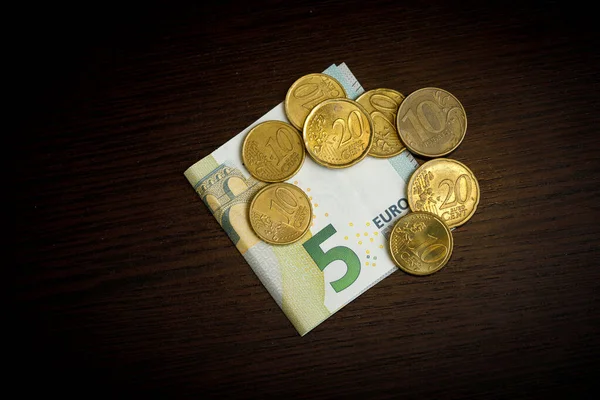 Monedas en euros sobre fondo de mesa de madera oscura — Foto de Stock